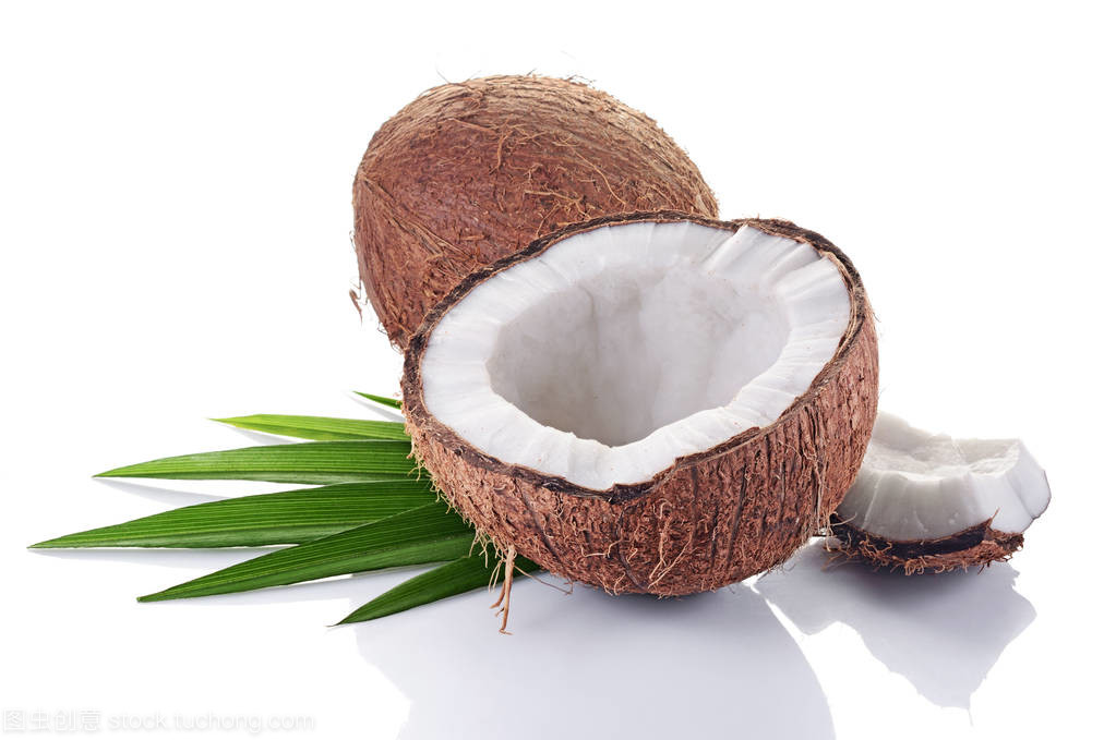 健康的食物。新鮮的椰子與綠色的棕櫚葉